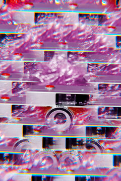 Abstract fragmented camera with rainbow optical layering and pink metallic background