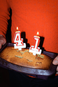 Homemade cake with birthday candles in baking tray during celebration