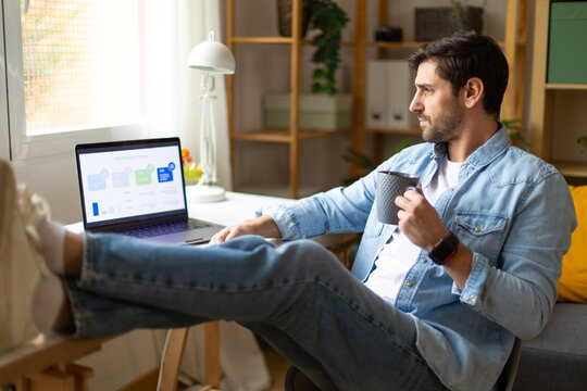 Freelancer working from home with laptop and coffee in casual home office