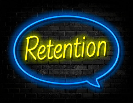 Leuchtende gelbe Neonschrift "Retention" umramt von einem blauen Neongesicht auf dunkler Backsteinmauer