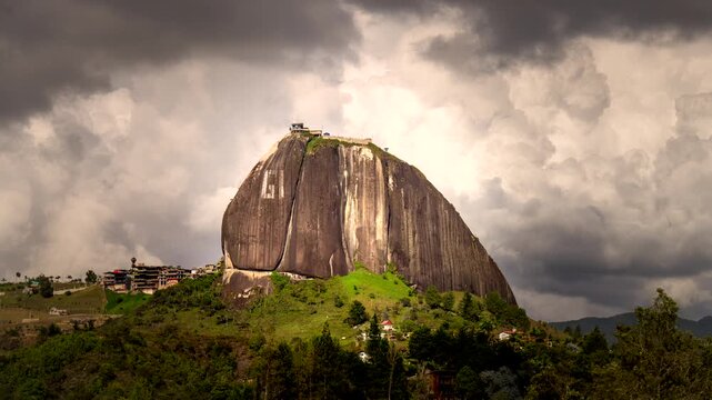 Cinematic Time-lapse of El Pe&ntilde;&oacute;n de Guatap&eacute; (La Piedra del Pe&ntilde;ol) near Guatap&eacute;, Colombia, as dramatic storm clouds race past the iconic granite monolith in changing light