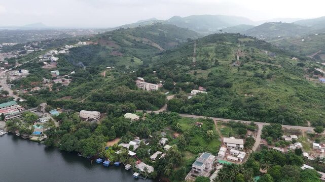 Panoramic drone shot of the tropical hills and water near Akosombo, Ghana. Scenic aerial view of the Volta River region and dense West African vegetation