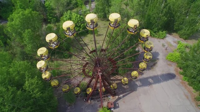 Aerial view of an abandoned Ferris wheel in Pripyat, Ukraine. Overgrown amusement park shows urban decay.