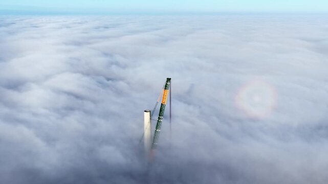 Crane pierces through thick cloud with brocken spectre phenomenon