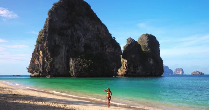 Bikini Woman Walking on Phra Nang Beach With Ko Rang in Background