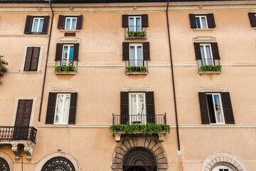 Obraz premium Traditional residential building facade with balconies and shutters in rome italy