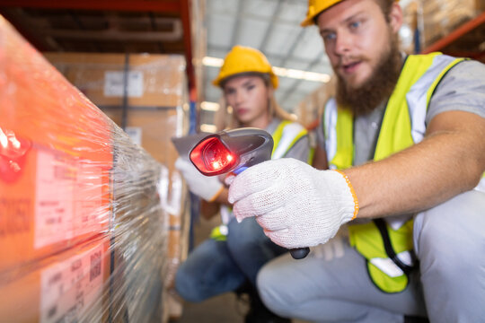 Warehouse workers scanning barcode with tablet in distribution center. Logistics team checking inventory and shipment boxes, supply chain management and industrial storage concept.