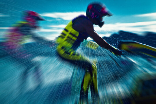 Two jet ski riders in action with heavy water spray on Lake Havasu, 35mm film scan against mountain range, illustrating teamwork and high-energy summer trend.