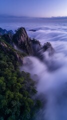 Obraz premium Misty mountain peaks above rolling cloud sea at dawn