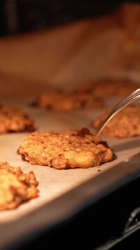A tray of cookies is baking in an oven. The cookies are golden brown and appear to be ready to be taken out