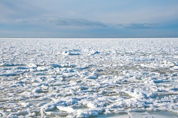 Panoramic view of vast drift ice and pancake ice floes on the frozen sea surface. Winter arctic landscape under a clear blue sky. Concept of global warming, climate change and polar exploration. © Igor