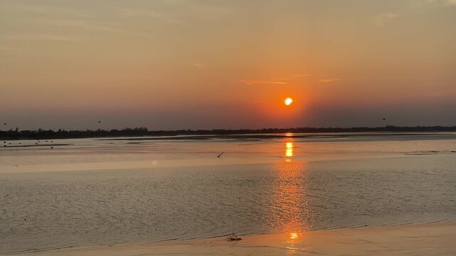 Sunrise Over Calm Water With Flock Of Birds Flying At Dusk Nature Scenery