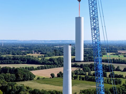 Luftbild: Schwerlastkran zieht Teil f&uuml;r den Hybridturm einre modernen Windkraftanlage hoch, Hochbau, Turmbau, Windenergie, Aufbau eines Windrads, Energiewende