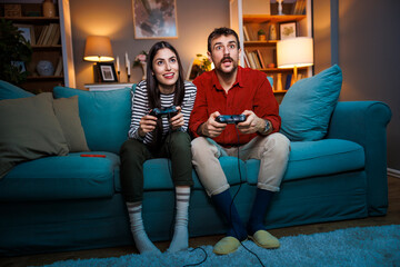 Obraz premium Couple having fun playing video games at home at night