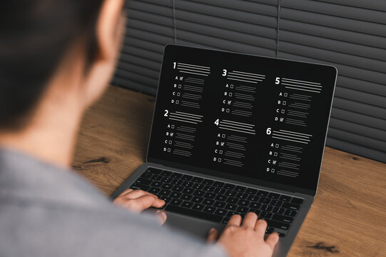 Online exam concept. Student taking digital multiple choice test on laptop screen highlighting remote assessment, e-learning evaluation system, academic quiz platform and virtual education technology.