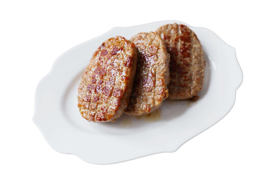 Three cooked sausage patties on a white plate ready for breakfast or as a meal option