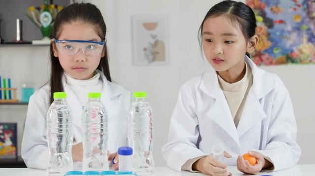 Asian Schoolgirls Conduct Bernoulli's Principle Science Experiment with Ping Pong Ball