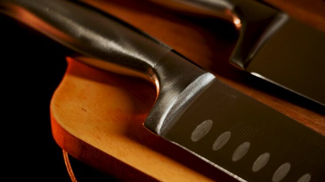 Knife close-up shows shiny blades on wooden cutting board in kitchen setting