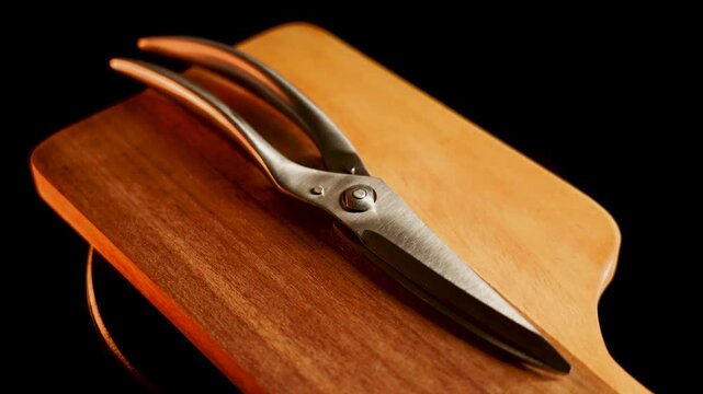 Sharp scissors rest on a wooden cutting board during a kitchen task