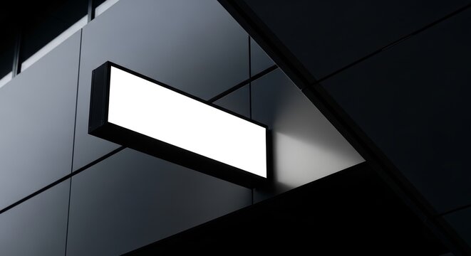 A contemporary blank rectangular light box sign mockup, prominently displayed on a sleek, dark building facade, ready for custom branding or advertisement.