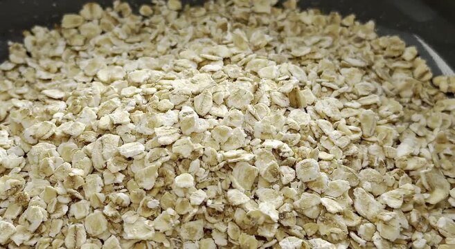 Close-up sequence of rolled oats in a bowl, showcasing texture and grain details, with natural lighting enhancing the visual appeal of the food product