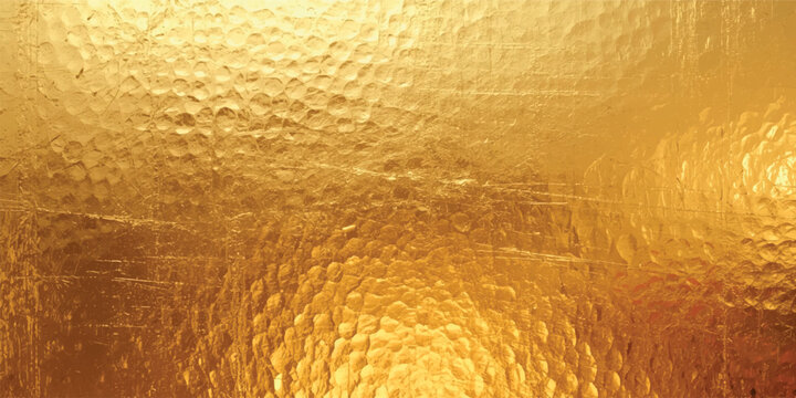 Golden hammered glass texture with warm luminous reflections abstract metallic translucent background