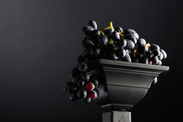 Naklejka premium Close-up of blue grapes on a black background.