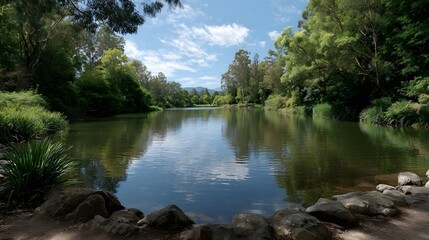 A serene lake reflects the cloudy sky and lush green trees offering a tranquil natural landscape perfect for peaceful contemplation