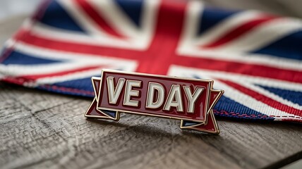 Victory in europe day pin badge resting on union jack flag fabric surface commemorating historical celebration of peace and end of world war two with classic british military style