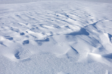 A snow covered ground with a few footprints