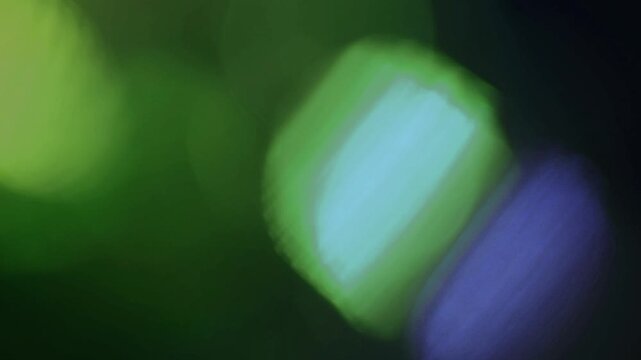 Light leak and bokeh overlay creating a dreamy, soft focus effect with glowing green orbs. This footage is ideal for adding atmosphere and visual flair to video projects.