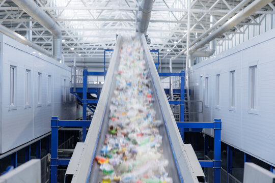 Recycling plant conveyor belt sorting plastic waste in industrial facility
