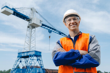 Smiling portrait of caucasian Foreman industrial engineer in white hard hat and blue safety uniform...