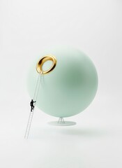 A miniature person climbing a rope towards a golden ring on a large mint-green orb displayed on a stand