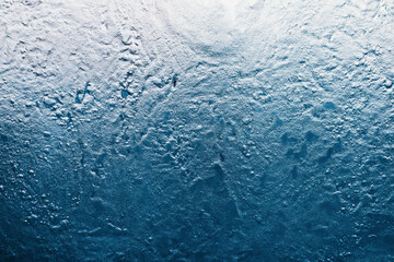 Frozen ice texture creating a cool, abstract winter background. Rough, granular surface showing cold temperatures and frozen liquid