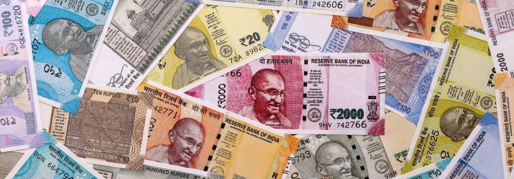 Indian rupee money bills pile on table. India banknotes of INR currency close up.