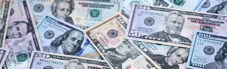 US dollar money bills pile on table. United States banknotes of USD currency close up.
