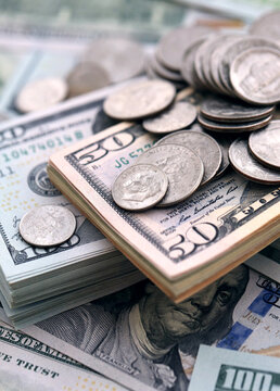 Big amount of United States coins on hundred and fifty dollar money bill wads on table