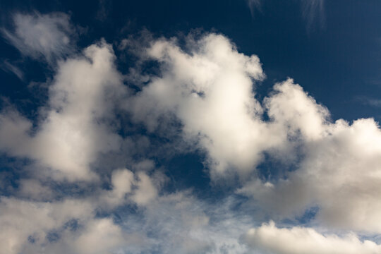 Grands nuages blancs vaporeux sur fond de ciel bleu fonc&eacute;