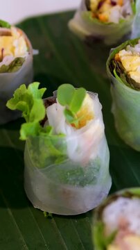 fried spring rolls nem drizzling savory sauce onto fresh Vietnamese pork rolls and herbs.