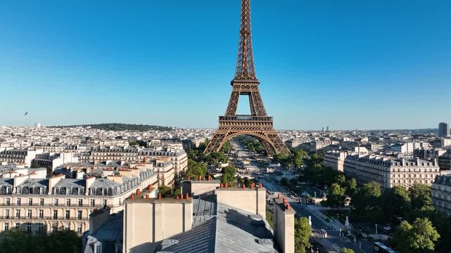 Eiffel Tower towering over Paris city rooftops on clear day