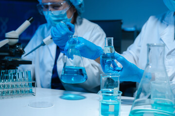 Fototapeta premium Lab work, Doctor holds a test tube takes the test from a test tube in analysis, blood, DNA, test tube stand.