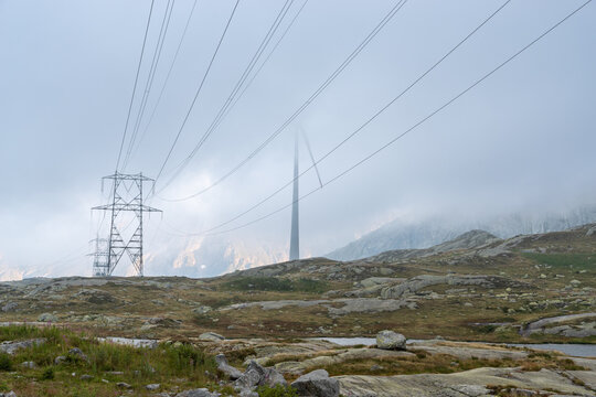 Power lines crossing foggy Passo del San Gottardo landscape