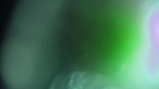 Light leak and bokeh overlay with green and white glowing effects. This footage is perfect for adding a cinematic touch or atmospheric element to your projects.
