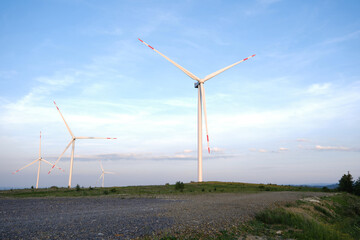 Fototapeta premium Wind Turbines on Hilltop Against Blue Sky
