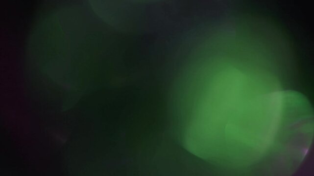 light leak and bokeh overlay of dark purple and green flares and highlights. This video is perfect for adding a cinematic feel to your projects.