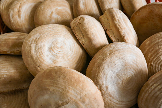 A lot of bread on a tray in a bakery. Real production.