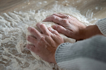 Fototapeta premium Woman kneading dough in kitchen preparing homemade bread