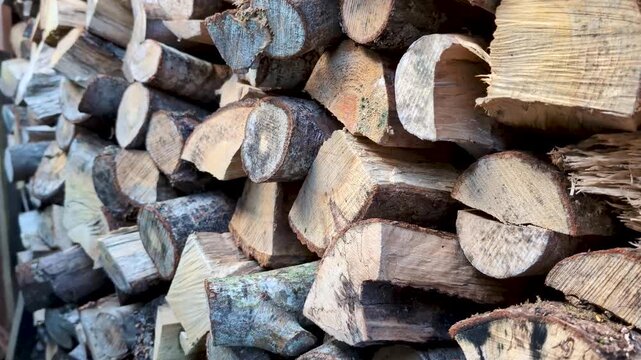 Close-up 4K footage of a stacked wood pile showcasing natural texture, rough bark, and organic patterns, perfect for rustic, nature, or background themes
