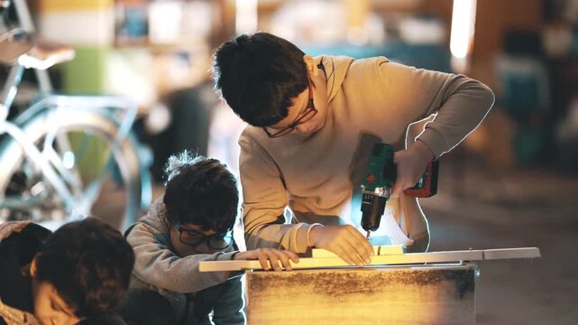 Young boys learning woodworking skills in a workshop